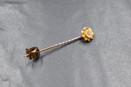 A yellow metal stick pin stamped 15ct having a diamond set terminal, approx 1.1g