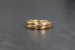 A 9ct gold diamond set band, the cross over style band having two pave set diamond chips with '