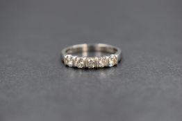 A platinum diamond set five stone ring, the round brilliant cut diamond measuring approximately 0.