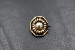 A yellow metal presumed gold pearl and enamel set mourning brooch, of curved octagonal form having a