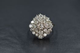 An 18ct white gold diamond set cluster ring, the central round brilliant cut diamond having two step