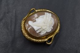 A yellow metal cameo brooch, the oval cameo depicting a maiden in profile with a foliate crown, in a