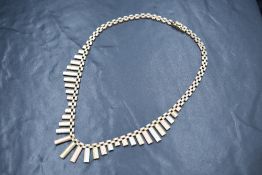 A 9ct gold three tone fringe necklace, the tank link necklace having graduated textured