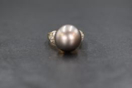 An 18ct gold pearl and diamond set ring, the central purple-grey possibly Tahitian pearl having five