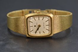 A Junghans wristwatch, the rectangular champagne dial having baton markers on a gold tone bracelet