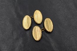 A pair of 1920's 9ct gold cufflinks having engine turned oval panels with chain connectors, approx
