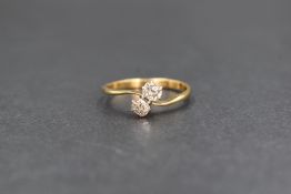 An 18ct gold diamond set toi et moi ring, the two old cushion cut diamonds in a twist setting,