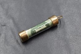 A 9ct gold mounted One Dollar pendant charm, of cylindrical form having a gold base and top,