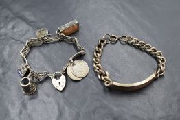 A silver curb link identity bracelet, along with a silver five bar gate bracelet with five charms,