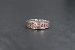 An 18ct white gold sapphire and diamond set band, the eleven graduated round cut pink sapphires in a