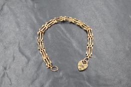 A 9ct gold three bar gate bracelet, with heart padlock clasp, marked 9ct, 16cm, 3.4g