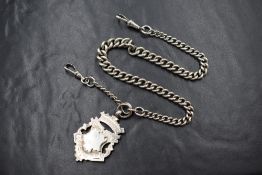 A silver graduated curb link watch chain, having dog clips and a silver shield medallion charm