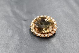 A 9ct gold brooch having a large central smoky quartz stone within a surround of seed pearls, approx