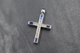 An 18ct white gold diamond and sapphire set cross pendant, the twelve central princess cut