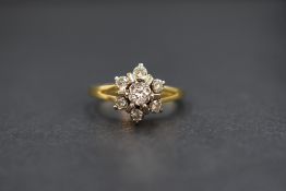 An 18ct gold diamond star burst cluster ring having seven brilliant cut diamonds, approx 0.256ct