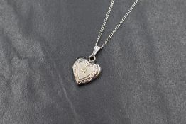 A 9ct white gold diamond chip set heart locket, having decorative engraving to the front, marked