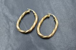 A pair of 9ct gold hoops, of oval form with a twist motif, marked 375, 3.8g