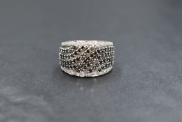 A 10ct white gold diamond set dress ring, having seven rows of black diamonds in an openwork wave