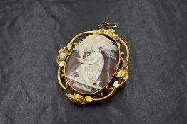 A yellow metal cameo set brooch, the cameo depicting Greek goddess Hebe offering nectar to Greek god