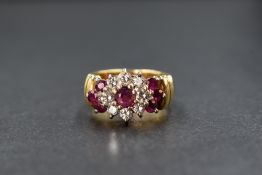 An 18ct gold ruby & diamond cluster ring having a central ruby, approx 0.25ct, within a surround