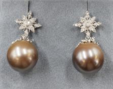 A pair of yellow metal presumed gold pearl and diamond set stud earrings, the cultured pearls having