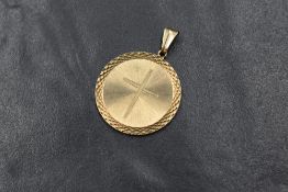 A 9ct gold pendant having an engraved cross within a sunburst surround, approx 23mm diameter & 4.2g