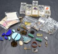 An assortment of loose gemstones and jewellery making items, including smoky quartz, dendridic