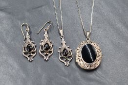 A white metal and Whitby jet mounted locket having a central panel within a pierced border on a