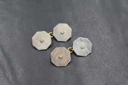 A pair of 18ct gold and platinum seed pearl set cufflinks, the octagonal panels having engine turned