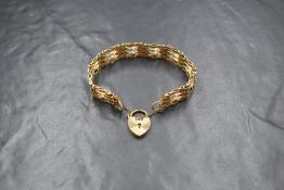 A 9ct gold four bar gate bracelet, having a heart padlock clasp, marked 375, 14.4g