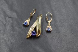 A 14ct gold tanzanite and diamond set suite of jewellery, the ribbon motif pendant having a