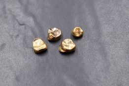 A group of four dental gold crowns, one having paste to the interior, 7.8g gross