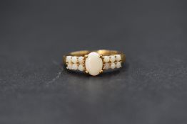 A 9ct gold opal set ring, the central oval cabochon having six round opal cabochons to each