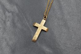 A 9ct gold cross necklace, the cross having scroll engraving to the front, on a box link chain,