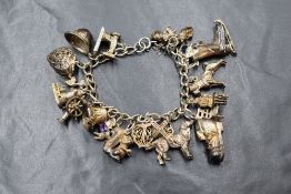 A silver charm bracelet having seventeen white metal charms, most stamped silver including: love