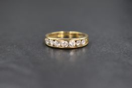 A 9ct gold cubic zirconia set band, the seven round brilliant cut cubic zirconia in a channel