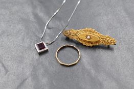 A small square ruby pendant in a white metal collared surround on a 17' white metal chain stamped