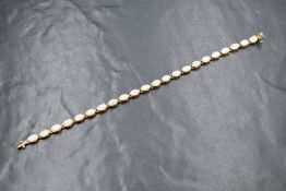 A 9ct gold opal set bracelet, the twenty-two oval cabochons in bezel settings with a box clasp,