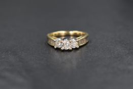 A 14ct gold diamond set three stone ring, the three graduated round brilliant cut diamonds measuring
