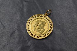 A Chinese yellow metal pendant, bearing marks, presumed gold, and inscribed Longevity & Good Fortune