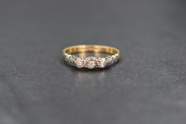 An 18ct gold diamond set trilogy ring, the three graduated illusion set diamonds measuring between