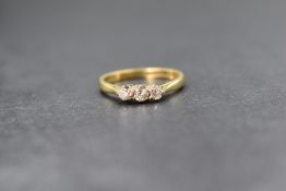 An 18ct gold diamond set trilogy ring, the three graduated diamonds measuring between