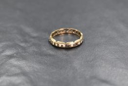 A 9ct gold colourless topaz set full eternity band, having decorative etches to the sides, marked