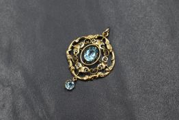 A 9ct gold Edwardian style paste set pendant, the central oval cut blue paste in an ornate scroll