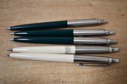 Five Parker ballpoint pens three in dark Green and two Ivory with Lustraloy caps