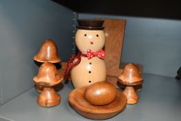 A small collection of turned wooden items including three graduated mushrooms, a book stand, an egg,