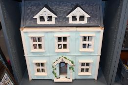 A Mid sized kit built children's dolls house over three floors with double hinged facade and