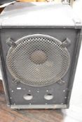 A large speaker cabinet , in peavey cabinet, on castors, speaker unidentified, possibly 15inch