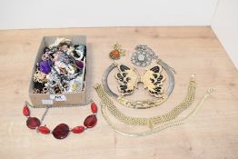 A collection of mixed costume jewellery, including large butterfly belt buckle, beads and various