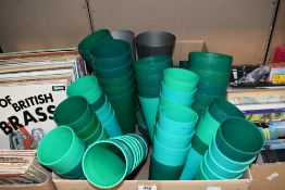 A large selection of assorted sized floristry beakers in greens and greys.